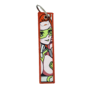Keychain with a repeating design of a red-haired woman in a white and green futuristic suit with green glasses.