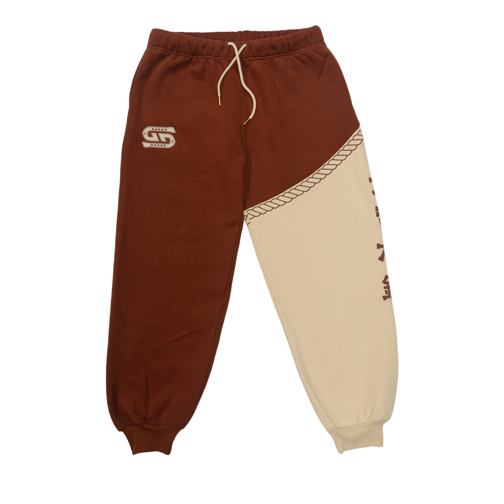 Rust-colored fabric with a white embroidered "G" logo featuring star details on the sweatpants.